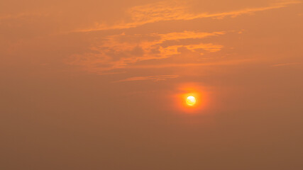 Beautiful big orange sun at sunset sky. Orange sky cloud and sun.