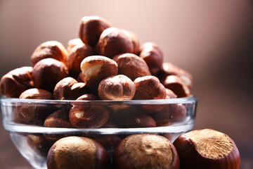 Bowl with hazelnuts on wooden table.