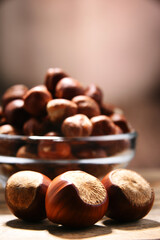 Bowl with hazelnuts on wooden table.