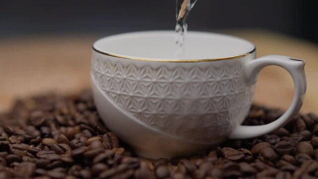 Coffee is poured into a cup. Pouring Coffee. into cup on grey background