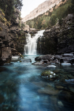 Water falls between brown rocky mountain