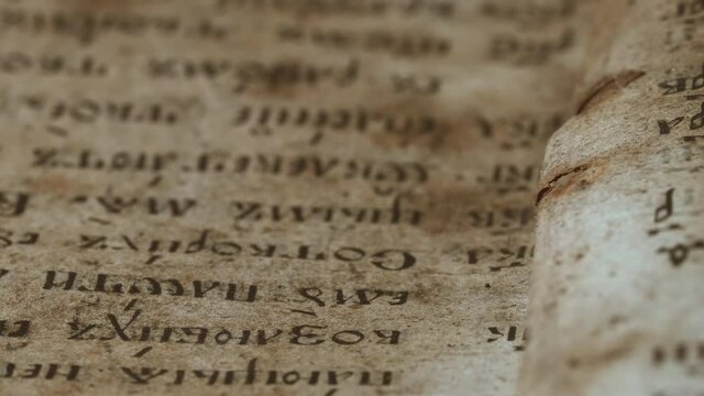 Slider shot over pages with candle wax stains of old antique religious book. Orthodox, psalter, 19th century, prayers and psalms. Cyrillic Church Slavonic font. History, archives and research concept.