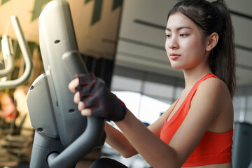 Fitness girl working out with stationary bicycle. Female athlete weight loss on exercise bike