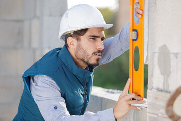 repairman measuring with the help of builder level