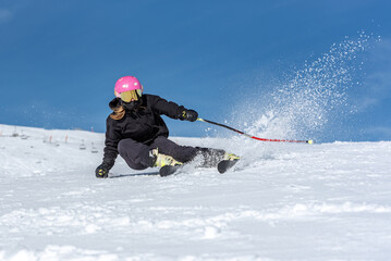 Fototapeta na wymiar Young blonde woman skiing on a sunny day