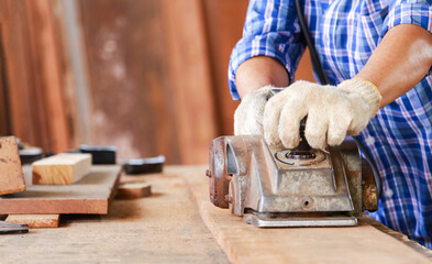 Close - up man's hand working with with electric planers outdoor.