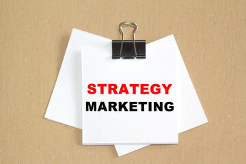 STRATEGY MARKETING text written on a paper. The concept of world business, marketing, finance.