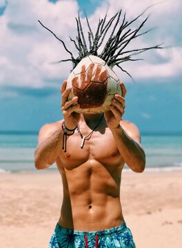 Topless man holding brown and white basketball