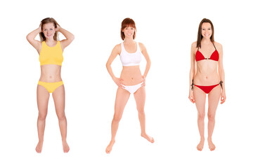 Full length portraits of three gorgeous laughing women wearing different bikinis, isolated in front of white studio background