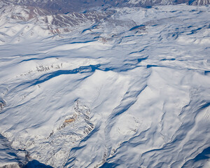 Fototapeta premium Flight over the Caucasus mountains by plane.