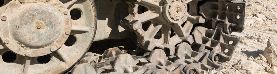 A close-up of the tracks of a heavy large excavator in a mining quarry.