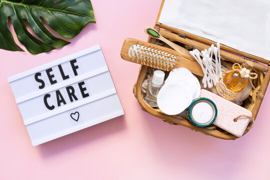 Self-care word on lightbox on pink background flat lay. Natural skin care products. Take care of yourself	