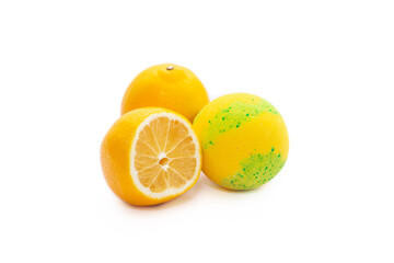 Aroma yellow-green bubbling round bright bath bomb near the lemons isolated on a white background. Close-up of lemon-flavored bath salt