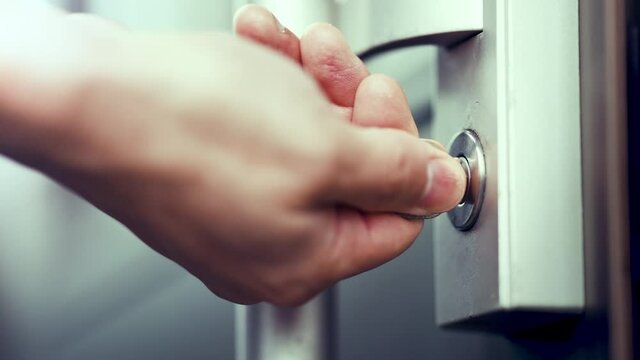 ドアのカギを開ける男性の手