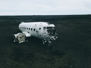 White and black airplane on green grass field under white sky