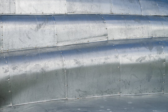 Sheet metal riveted, waved, weathered surface background image.