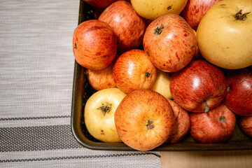 Basket with natural red and yellow apples on table.