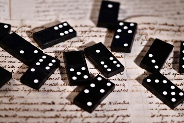 Dominoes on dark background of written pages