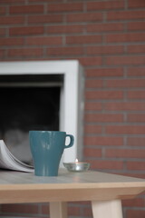 Cup of tea and a candle on the table 