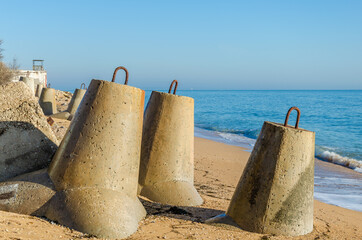 Concrete barriers against waves on the sea beach.