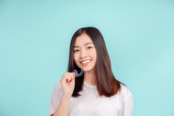 Dental Beautiful smiling of young asian woman with retainer braces glad emotion with white teeth increase confidence for healthy on blue background isolated, Happiness teenager facial expression.