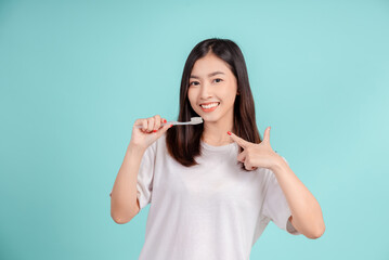 Dental Beautiful smiling of young asian woman teach correct teeth brushing  and toothbrush for white teeth increase confidence for healthy on blue background isolated, Happiness facial expression.