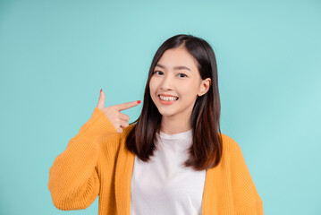 Dental of young asian woman wearing retainer braces glad emotion with white teeth increase confidence for healthy on blue background isolated, Happiness teenager smiling facial expression.