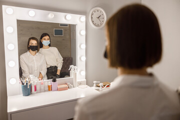 Fototapeta premium Professional brow master is doing her job for beautiful caucasian woman at beauty salon