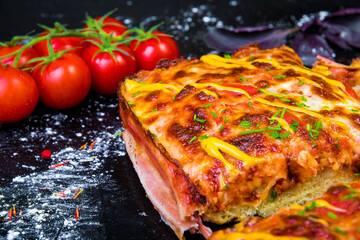 Homemade meat pizza pie with bacon sliced close-up on the table. horizontal view from above.