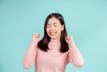 Fototapeta premium Dental braces of young asian woman wearing retainer braces glad emotion with white teeth increase confidence for healthy on blue background isolated, Happiness teenager smiling facial expression.
