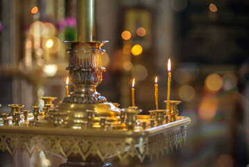 burning yellow candles in the Church, standing on a pedestal