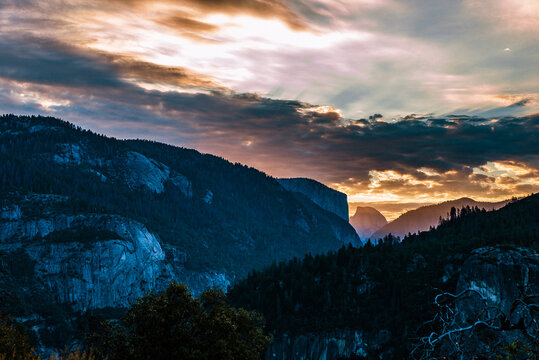 Green trees on mountain under cloudy sky