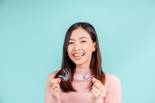 Dental Beautiful smiling of young asian woman with retainer braces glad emotion with white teeth increase confidence for healthy on blue background isolated, Happiness teenager facial expression.