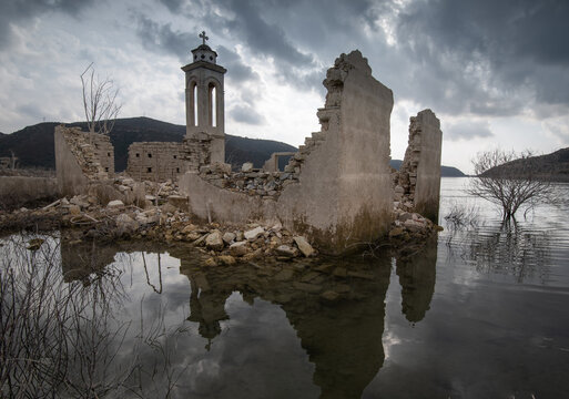 Ruins of an abandoned and deserted church in the water of a dam.