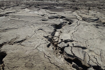 Water-washed land. Cracked crumbling clay and sandy soil after the snow melts in the spring or flood. concept of soil erosion climate change and sudden changes in air temperature and natural disasters