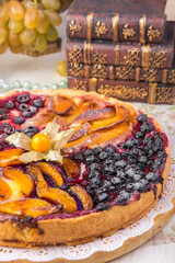 Berry pie, a tart filled with jam made from black currants, in glass form a gray background. Selective focus, close-up.