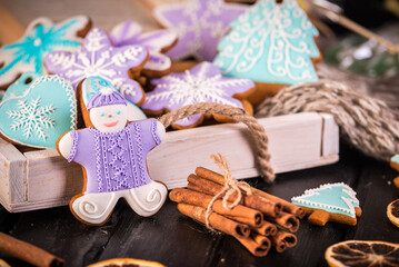 Gingerbread christmas cookies, snowflakes an gingerman. Knitted scarf and cinnamon sticks. 2019 New Year