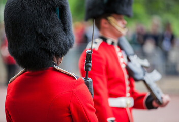 British army guard in red tunic and bearskin on parade at the Trooping of the Colour event in London