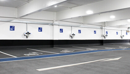 Row of empty electric car charging stations in indoor parking garage