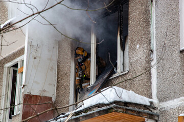 Obraz premium Fire in an apartment building, firefighters arrived in fire trucks and extinguish the fire