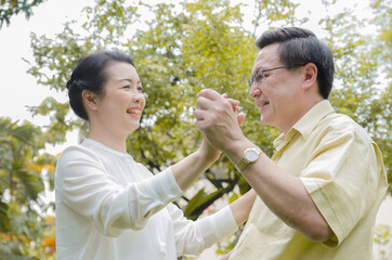 Obraz premium Asian senior couple smiling, happy, at home living a good life after retirement And have financial planning and health insurance