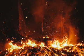 Brown sail boat on fire during night time