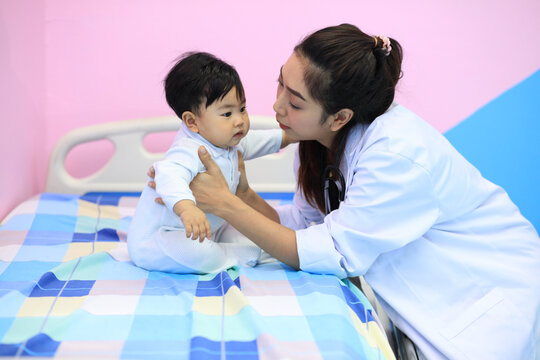 Cute doctor play with babay make relation before check health, black paediatrician check heart lungs of kid