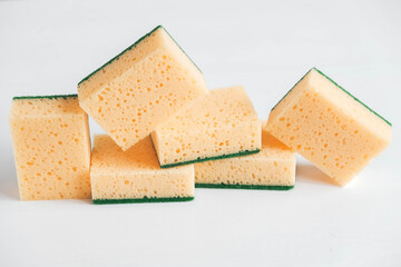 Yellow porous sponges on a white background. Top view. Copy, empty space for text