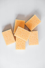 Yellow sponges on a white background. Top view. Copy, empty space for text