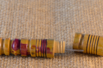 Estuche de madera en forma de tubo para guardar agujas de coser y enroscar hilo en sus ranuras...