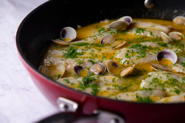 Fish with clams cooked al pil pil, traditional recipe from Bilbao, north spain.