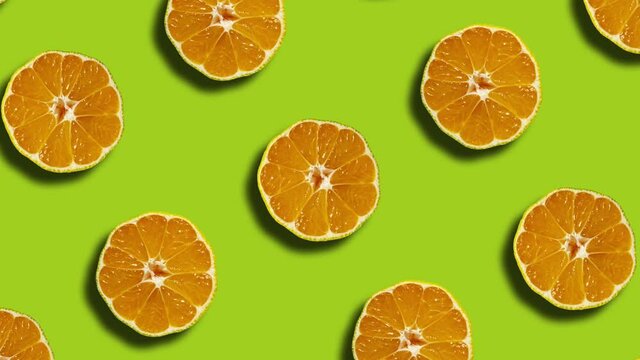 Pattern with mandarins in geometric grid on a green background. Minimal seamless motion graphics nature fruit animation