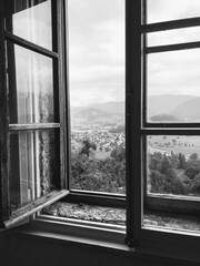 countryside views through black and white open wooden window.