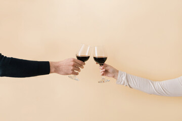 Hands of man and woman toast glasses with red wine.Minimal love concept